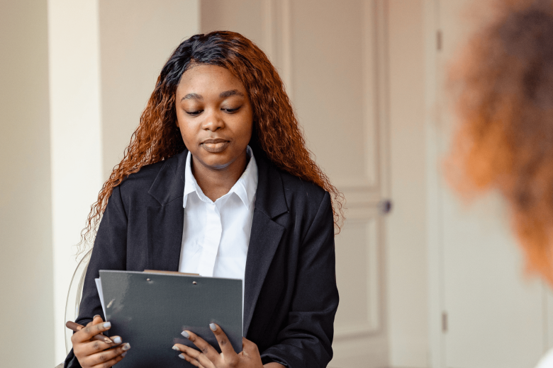 woman in a business suit looking at a clipboard