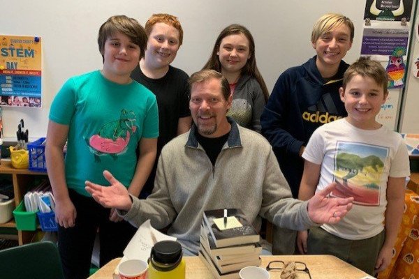 alum john mercer author with students