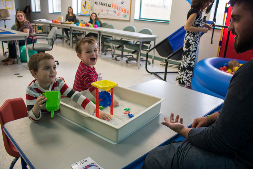 Student interacts with children in classroom.
