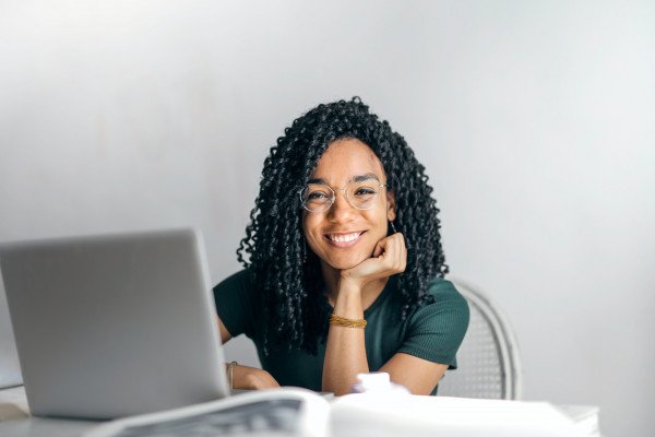 happy ethnic woman sitting at table with laptop 3769021 v3