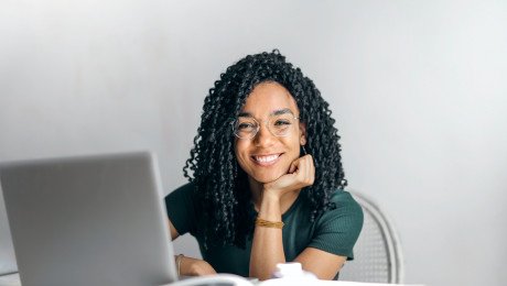 happy ethnic woman sitting at table with laptop 3769021 v3